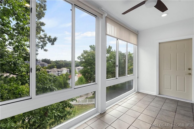 unfurnished sunroom featuring a healthy amount of sunlight and ceiling fan