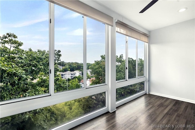 unfurnished sunroom with ceiling fan