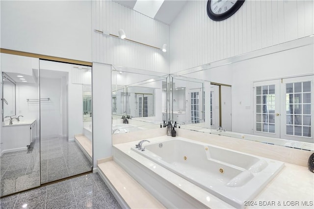 bathroom with independent shower and bath, vanity, a towering ceiling, and french doors