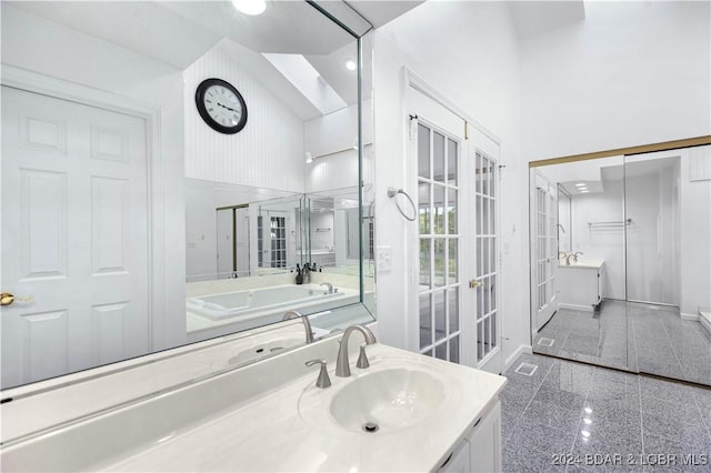 bathroom featuring vanity, a towering ceiling, and french doors