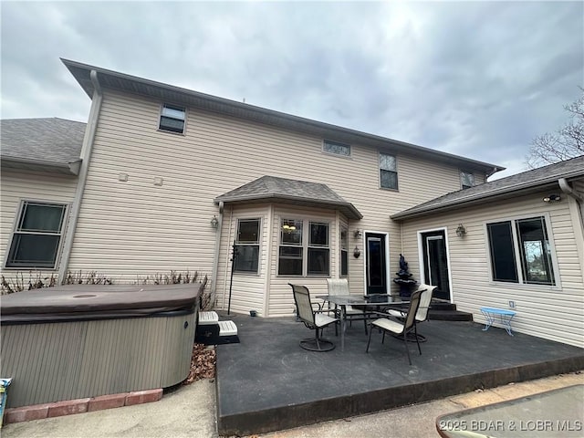 back of house featuring a patio area and a hot tub