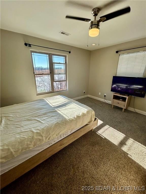 unfurnished bedroom featuring ceiling fan and dark colored carpet