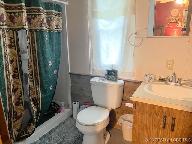 bathroom featuring a shower with shower curtain, vanity, and toilet