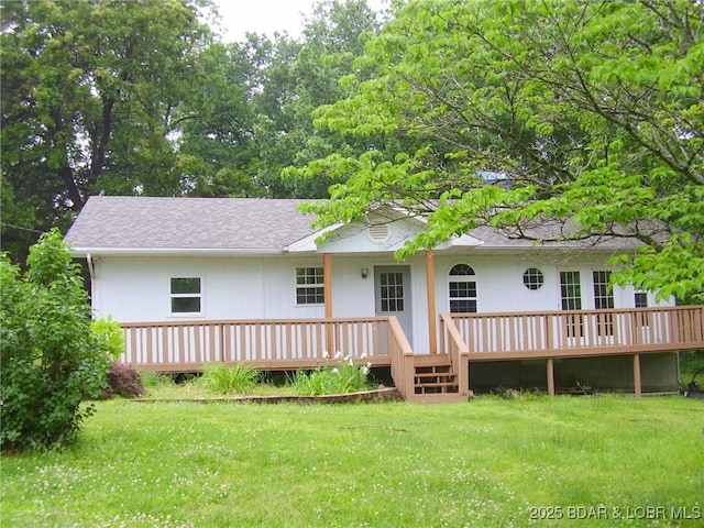 rear view of property with a yard and a wooden deck