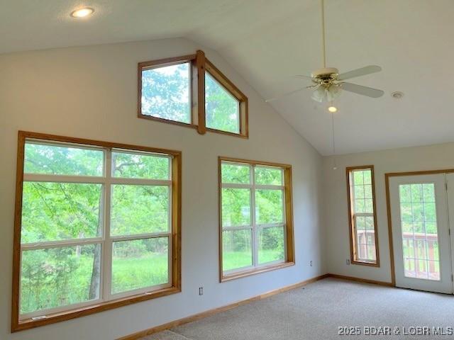 carpeted empty room featuring ceiling fan and lofted ceiling