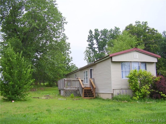 rear view of property featuring a yard and a wooden deck