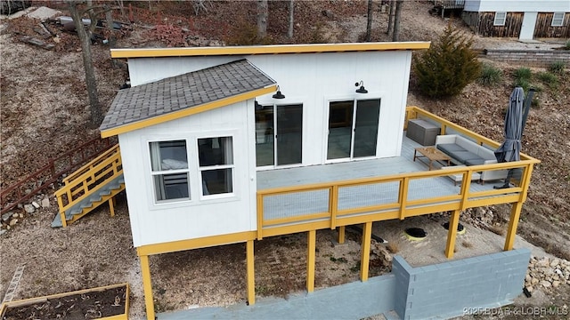 rear view of house with a shingled roof and an outdoor structure