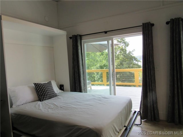 bedroom featuring access to exterior and light wood finished floors