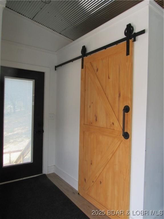 interior space featuring a barn door and baseboards