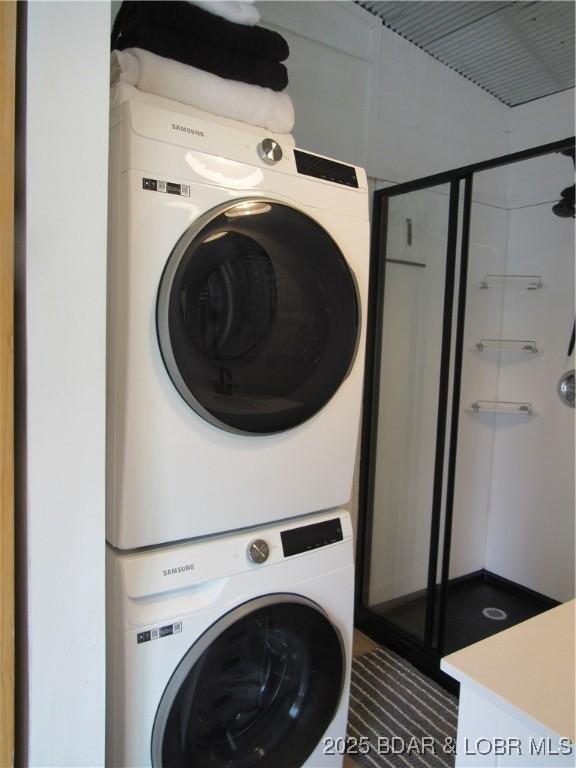 laundry room featuring laundry area and stacked washer / drying machine