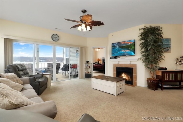 living room with light colored carpet, ceiling fan, and a fireplace