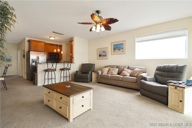 living area featuring light carpet and ceiling fan