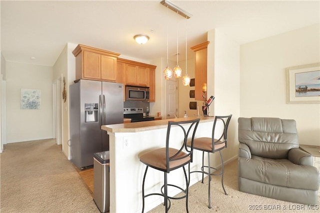 kitchen featuring tasteful backsplash, a breakfast bar area, light carpet, a peninsula, and stainless steel appliances