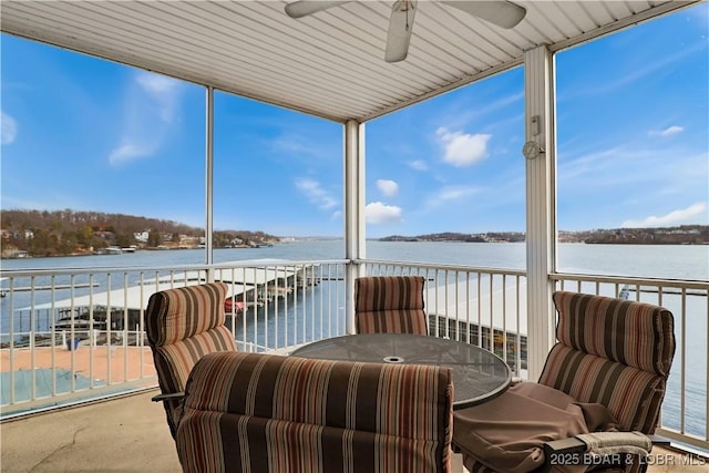 sunroom with a wealth of natural light, ceiling fan, and a water view