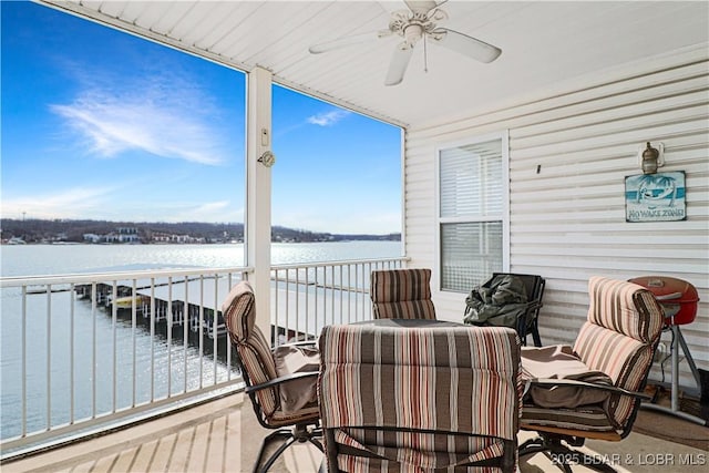 wooden terrace featuring a ceiling fan and a water view