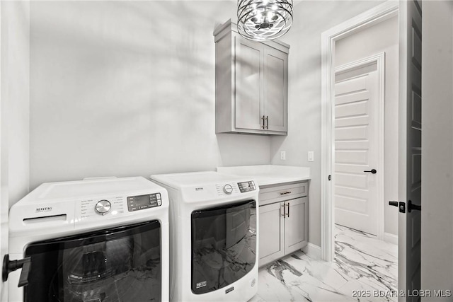 laundry area with washer and clothes dryer, cabinets, and an inviting chandelier