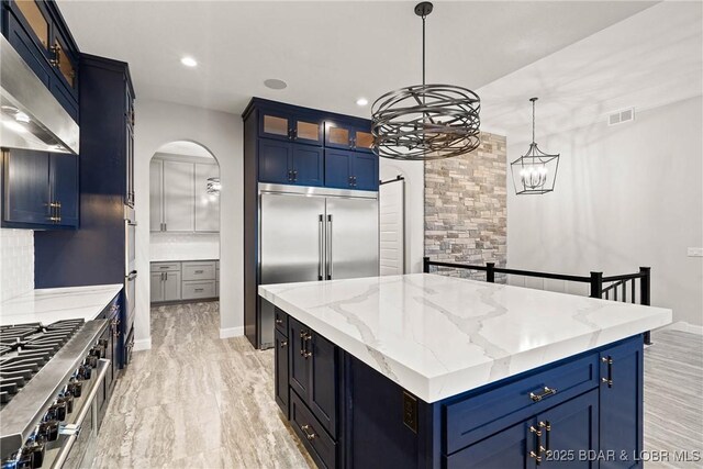 1536 Shootout Dr, Osage Beach, MO 65065 - kitchen featuring range hood, cooktop, a kitchen island, built in refrigerator, and arched walkways
