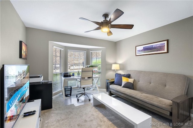 carpeted office space with ceiling fan