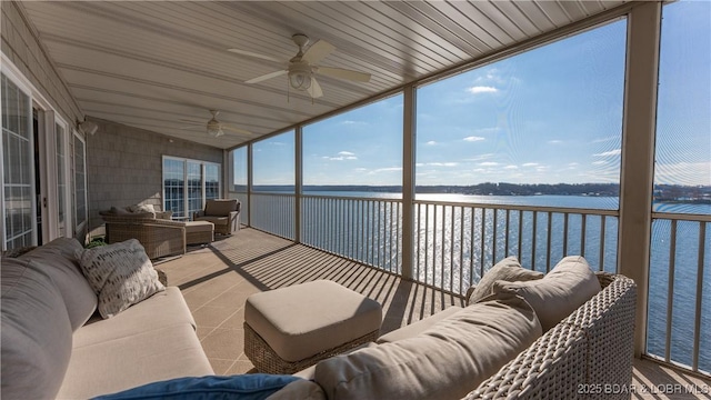 sunroom / solarium with a water view and ceiling fan