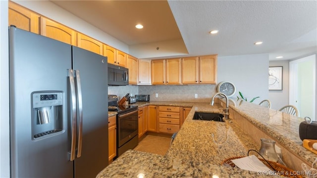 kitchen featuring light stone countertops, stainless steel refrigerator with ice dispenser, backsplash, electric range oven, and sink