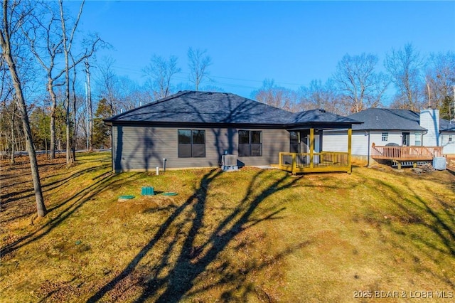 rear view of house featuring a yard and a deck