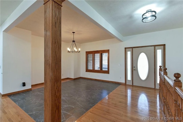 foyer with a chandelier, dark hardwood / wood-style floors, and beamed ceiling