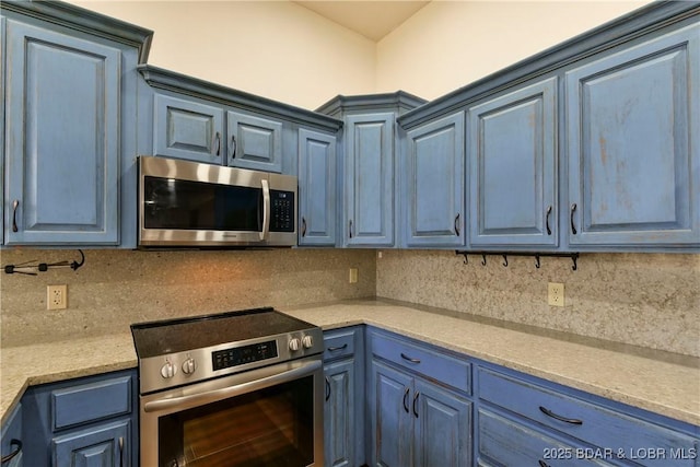 kitchen with blue cabinetry, tasteful backsplash, and stainless steel appliances