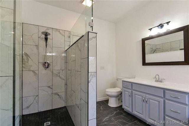 bathroom with vanity, toilet, and tiled shower