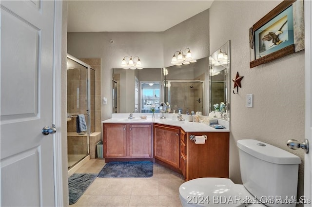 bathroom with toilet, vanity, tile patterned floors, and a shower with shower door