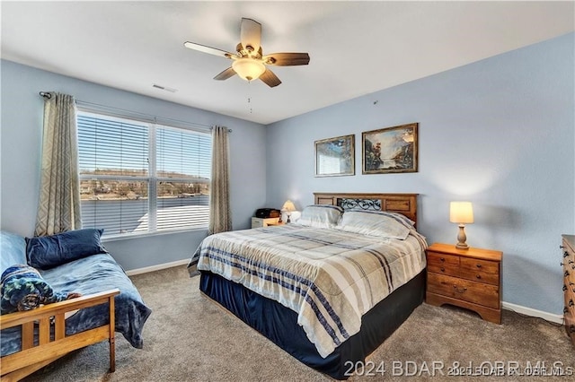 carpeted bedroom with ceiling fan and a water view