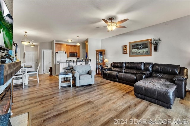 living room with ceiling fan and light hardwood / wood-style flooring