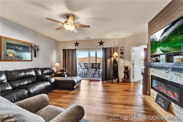 living room with a fireplace, hardwood / wood-style floors, and ceiling fan