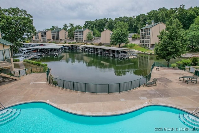 view of pool with a water view and a patio area