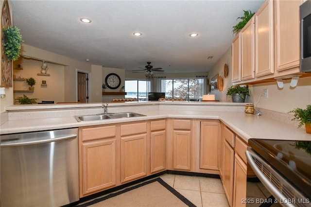 kitchen featuring sink, light brown cabinets, kitchen peninsula, light tile patterned floors, and appliances with stainless steel finishes