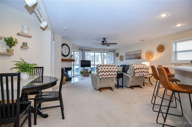 carpeted living room with ceiling fan