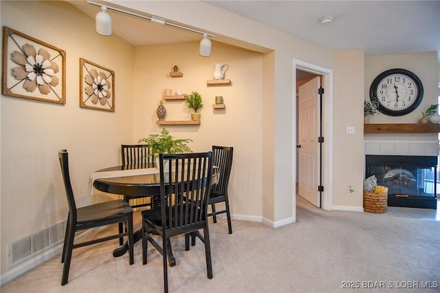 carpeted dining space featuring a fireplace