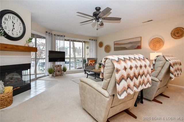 carpeted living room featuring a fireplace and ceiling fan