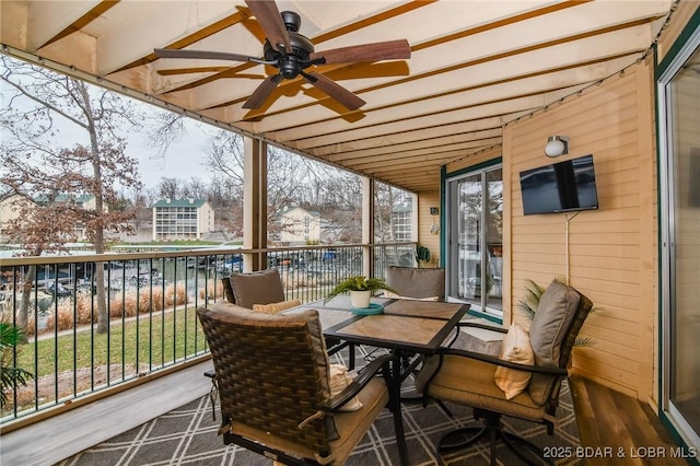 sunroom / solarium featuring ceiling fan, plenty of natural light, and lofted ceiling