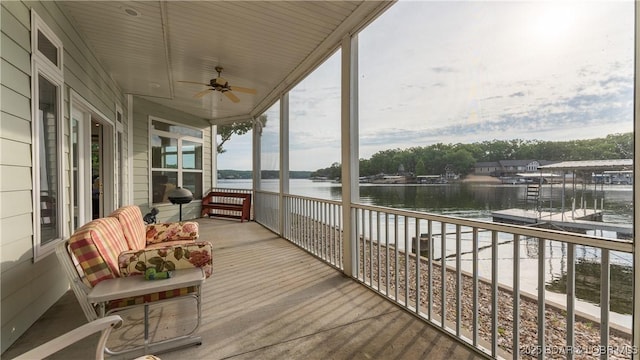 sunroom featuring a water view and ceiling fan