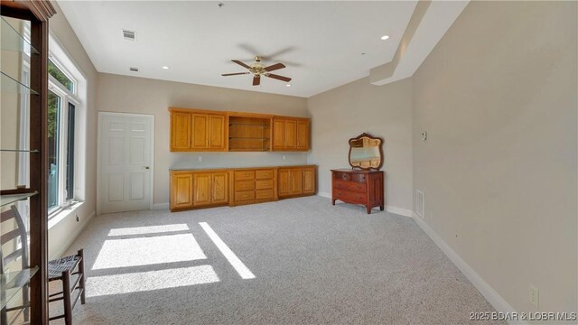 interior space featuring plenty of natural light, ceiling fan, and light colored carpet