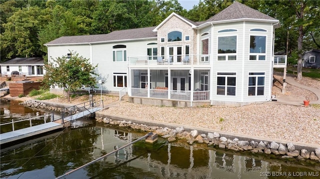 rear view of house with a water view and a balcony