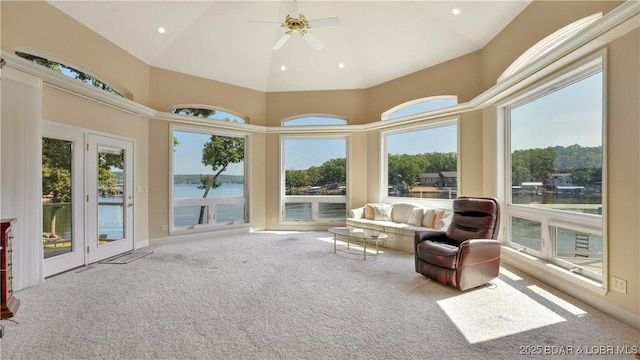 sunroom with ceiling fan, plenty of natural light, and a water view