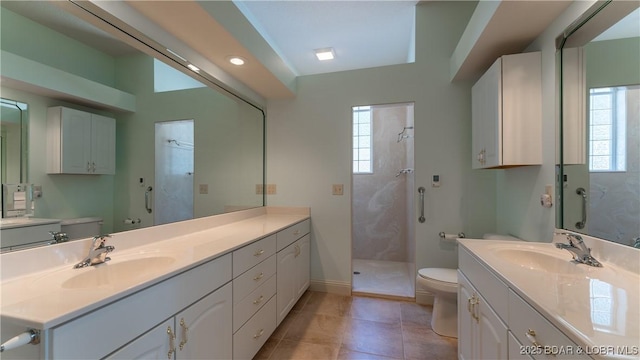 bathroom featuring a tile shower, vanity, and toilet