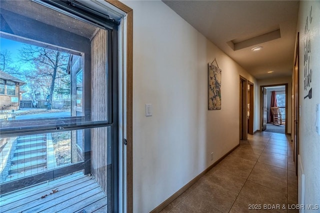 corridor with tile patterned floors and a healthy amount of sunlight