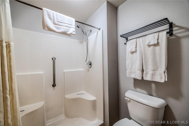 bathroom featuring a shower, a textured ceiling, and toilet