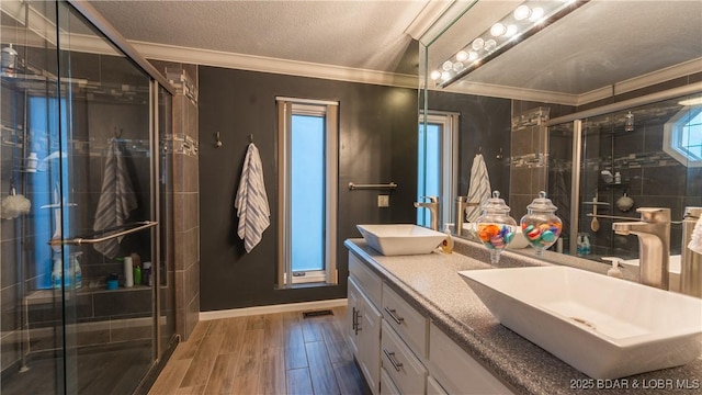 bathroom featuring crown molding, a shower with door, vanity, and wood-type flooring