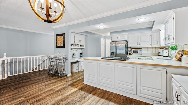 kitchen featuring kitchen peninsula, appliances with stainless steel finishes, white cabinets, and sink