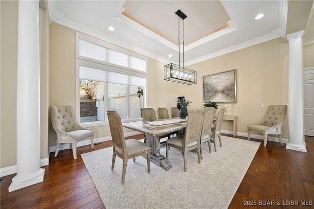 dining room featuring dark wood finished floors, ornate columns, ornamental molding, and baseboards