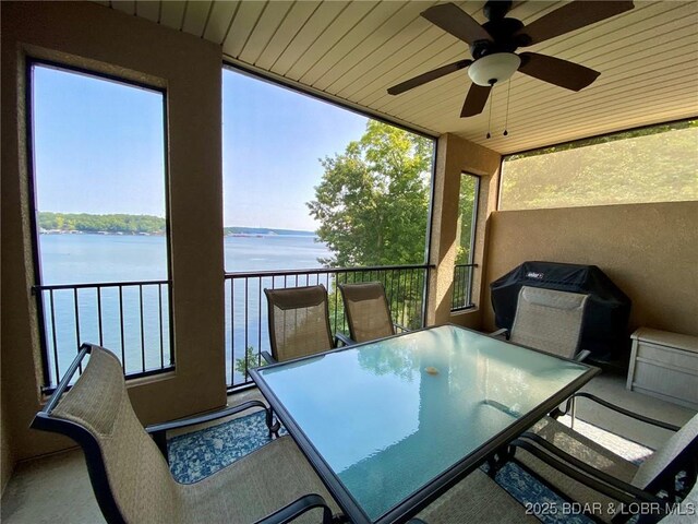 sunroom with a water view and ceiling fan