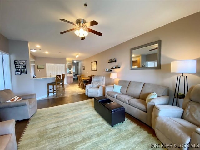 living room featuring dark wood-type flooring and ceiling fan